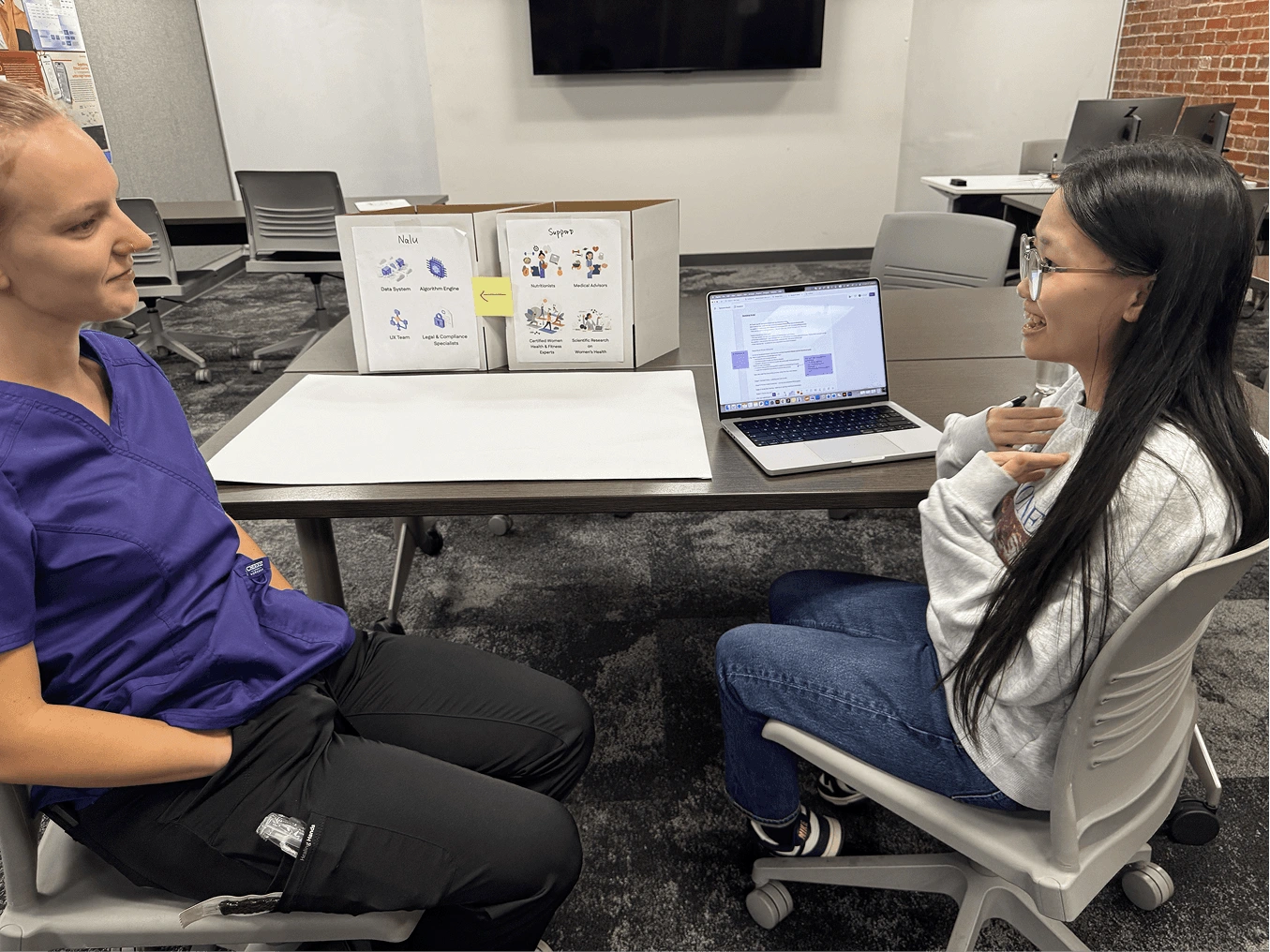 A participant and researcher discussing the Nalu prototype during a wireframe walkthrough